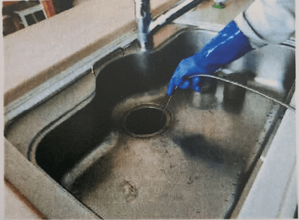 キッチンシンクの排水管清掃作業中
